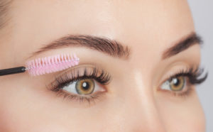 Beautiful Woman with long eye lash extensions in a beauty salon. Eyelash extension procedure. Cosmetology skin care